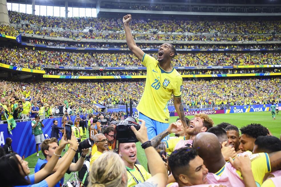 Rayan sobe em placa de publicidade e comemora gol de Martinelli em Brasil x Japão — Foto: Carlos Ramírez/EFE